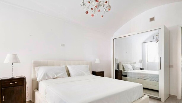 Ein Schlafzimmer mit einem großen Bett, einem Kleiderschrank und einer Chandelüster.