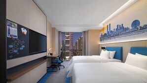 Une chambre d’hôtel avec deux lits, un bureau, une chaise, une télévision et une grande fenêtre donnant sur le paysage urbain.