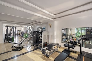 A gym with various exercise equipment, a mirror, and a large window. - Sea Beside Me Hotel & Suites (Da Nang)