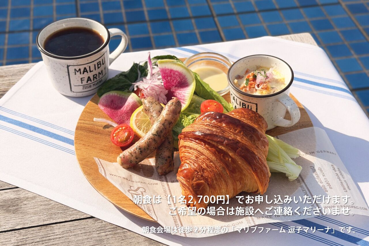 Ein Frühstückstisch mit einem Croissant, einer Kaffeetasse, einem Salat und einer Suppenschüssel.