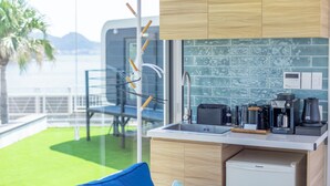 A modern kitchen with wooden cabinets, a built-in microwave, and a coffee maker. - SPACE KEY POINT RIVIERA ZUSHI MARINA (Zushi)