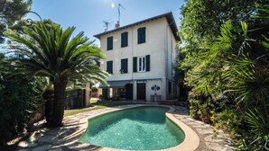 A two-story building with a swimming pool, surrounded by lush greenery and stone pathways. - 2BR Cozy Villa Saint-Jean-Cap-Ferrat (Saint-Jean-Cap-Ferrat)