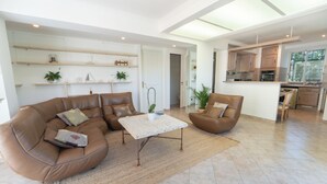 A spacious living area with a brown leather sofa, a coffee table, and a kitchen in the background. - 2BR Cozy Villa Saint-Jean-Cap-Ferrat (Saint-Jean-Cap-Ferrat)