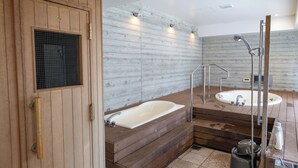 Ein modernes Badezimmer mit einem Holzbadezimmer-Möbel, einer freistehenden Badewanne und einem großen Spiegel.
