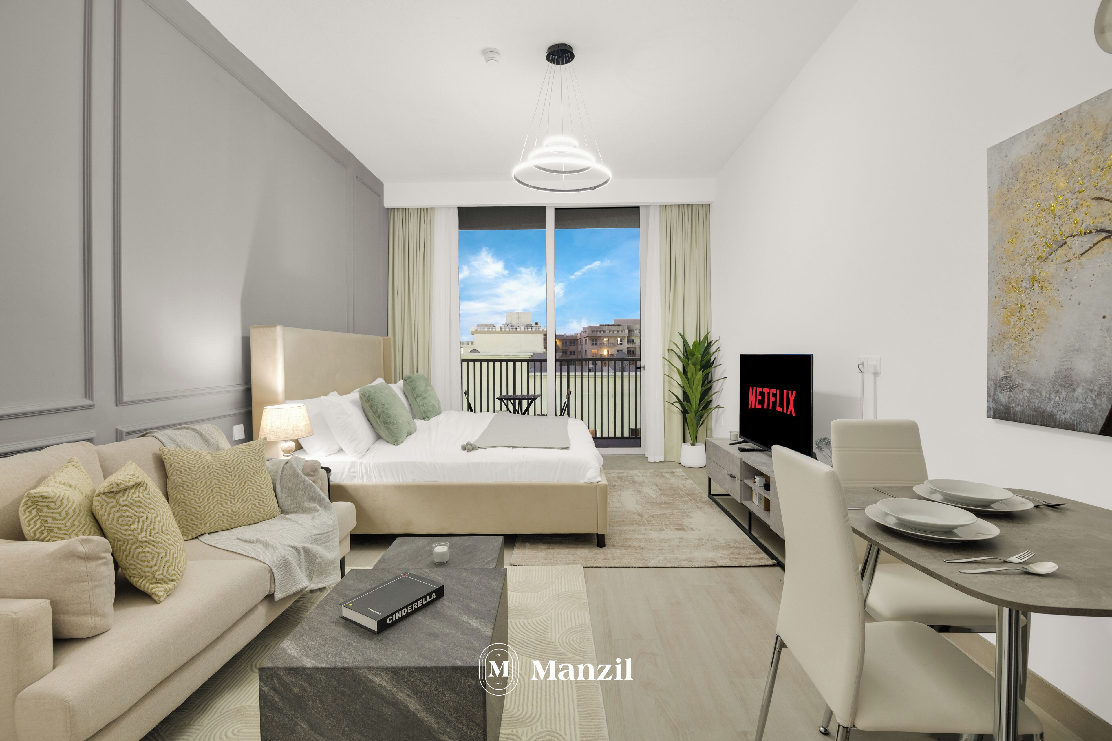 Una habitación de hotel moderna con una cama, un sofá, una mesa de comedor con sillas, un televisor y un balcón con vistas a edificios.
