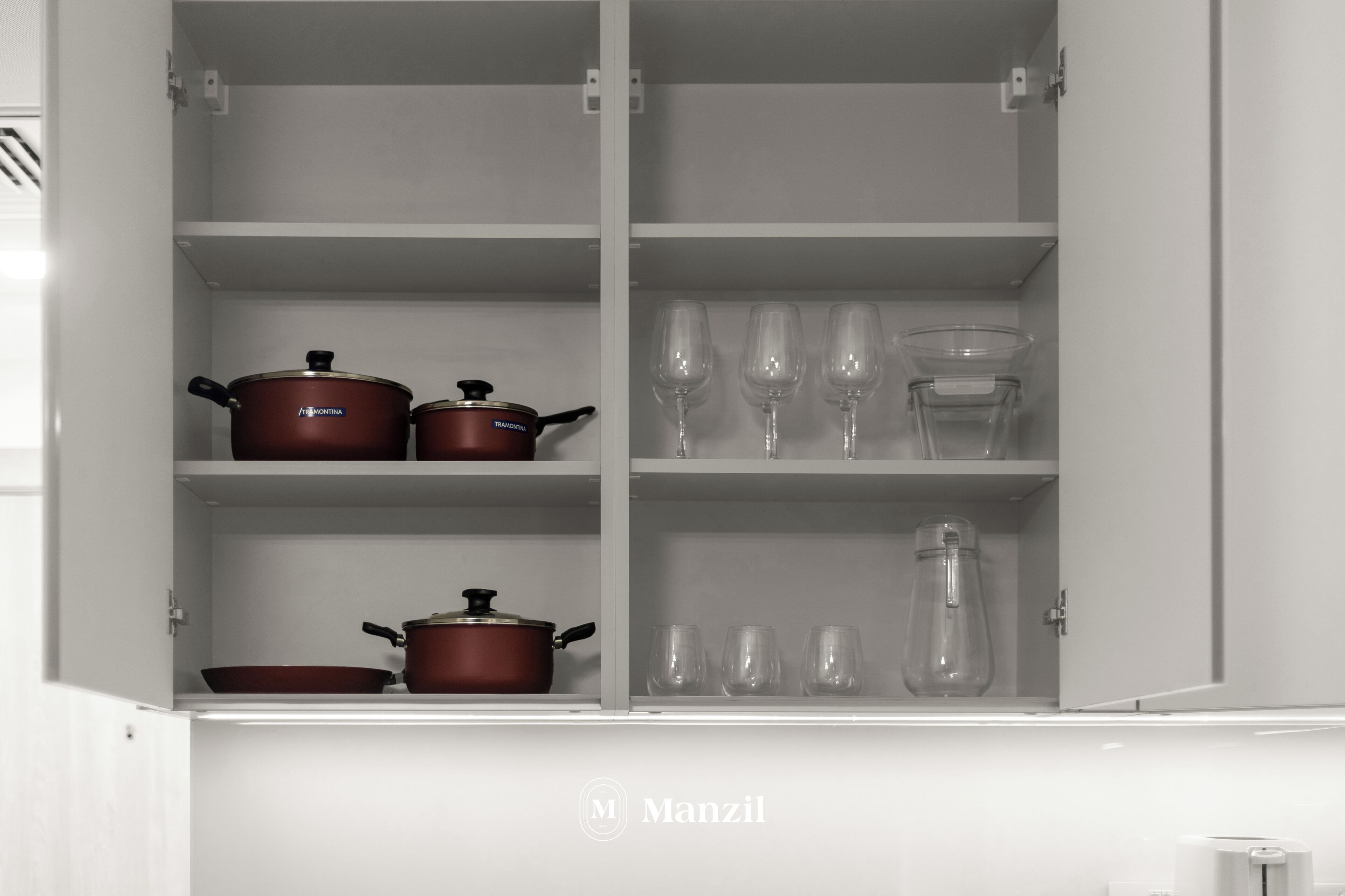 A kitchen cabinet with shelves containing cookware and glassware.