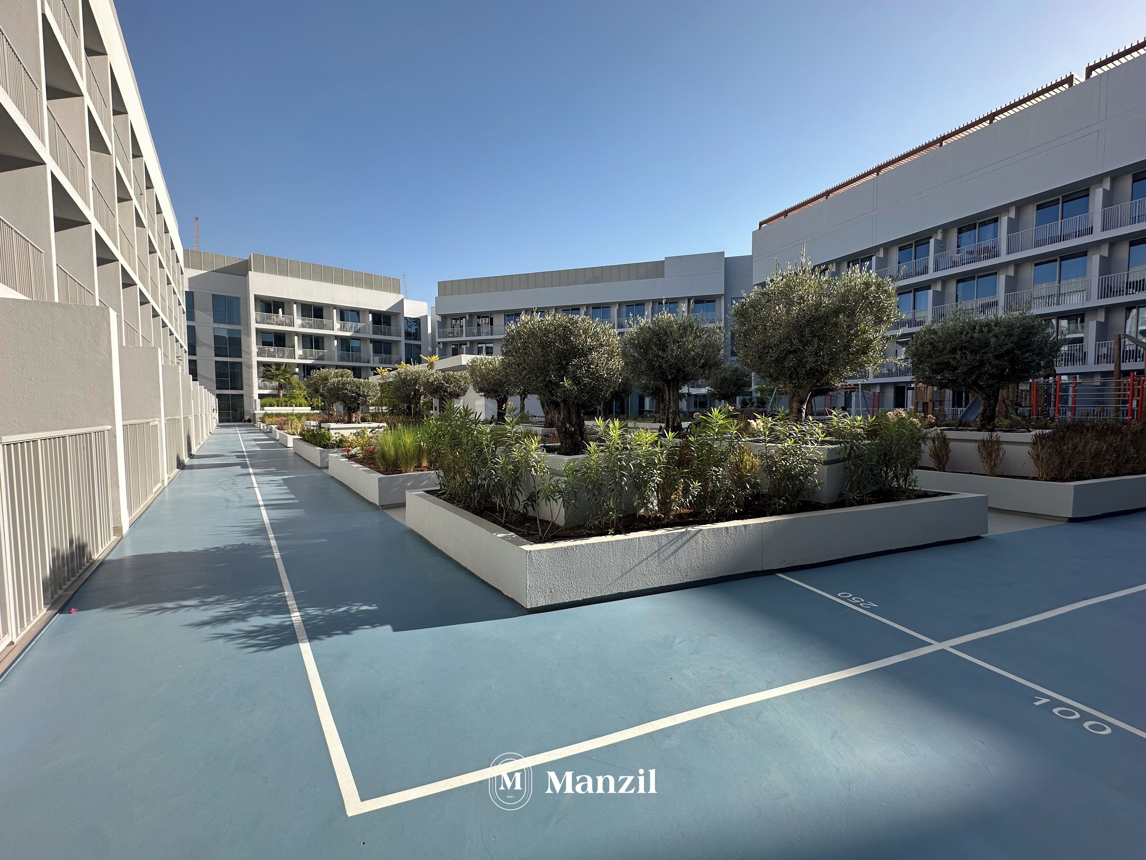 A modern building with a courtyard featuring planters with various plants and trees.
