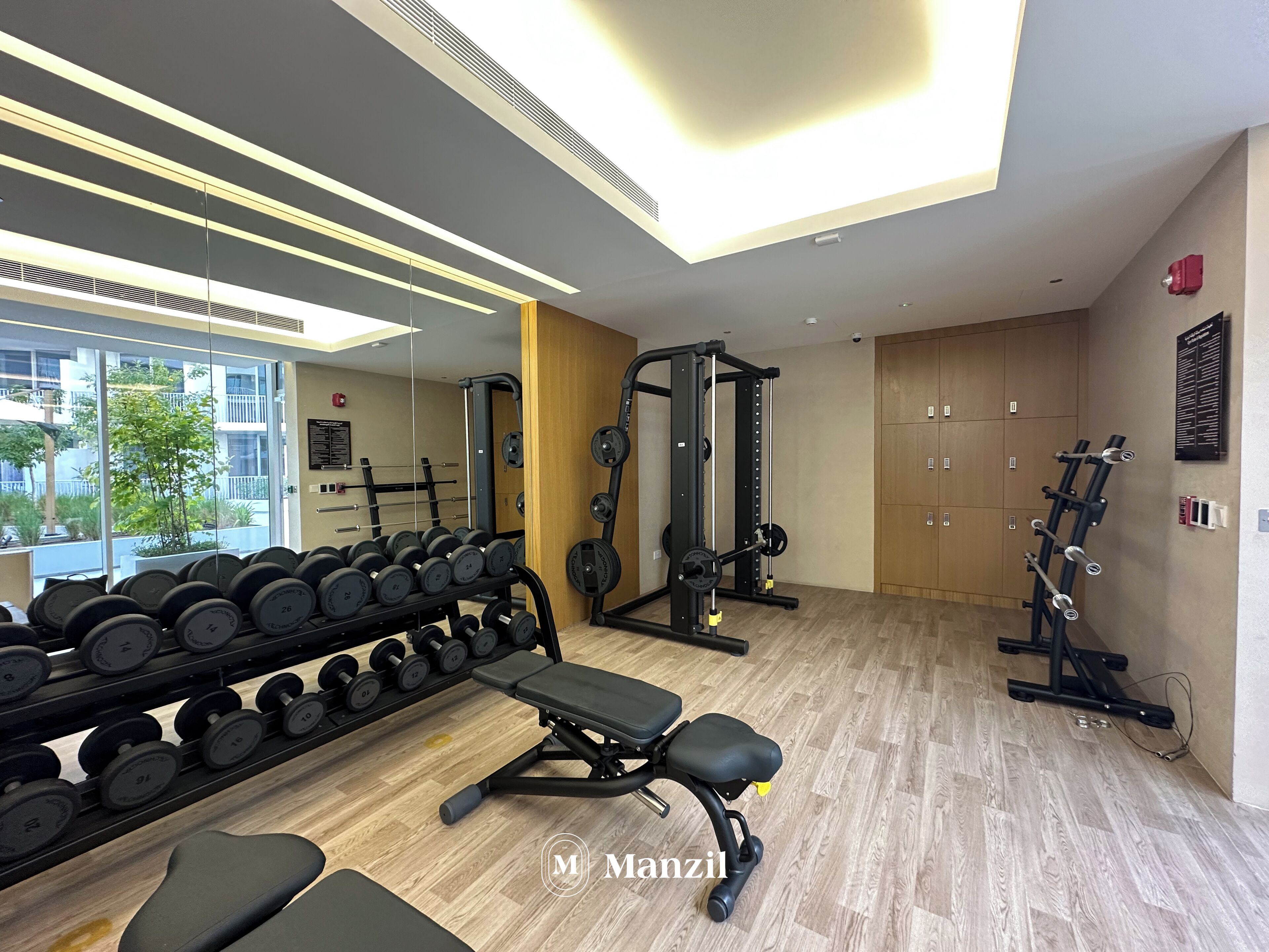 Academia moderna com equipamentos de musculação, pesos e um suporte de halteres.