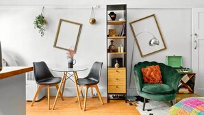 Un espacio moderno para vivir con comedor, un sillón verde y una estantería.