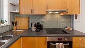 Een keuken met houten kastjes, een roestvrijstalen spoelbak, een koffiezetapparaat en een broodrooster.
