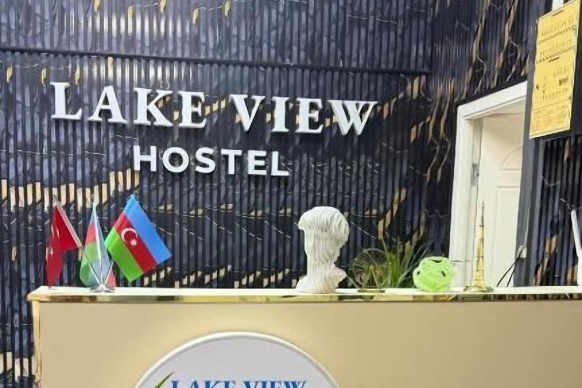 Un comptoir d’accueil orné du logo de l’auberge Lake View Hostel, de quelques drapeaux et d’un objet décoratif.
