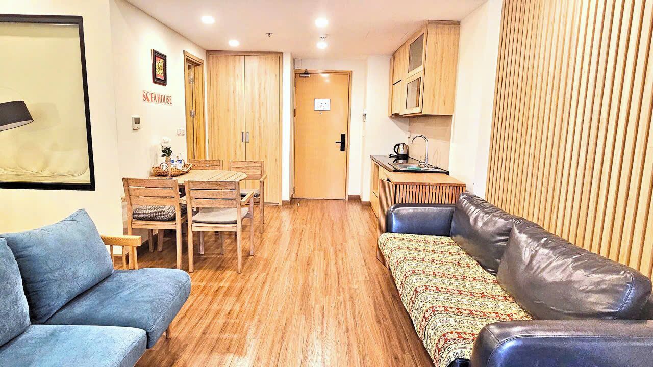 A compact living space with a kitchenette, a dining area, and a sofa.