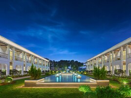 Un hotel con piscina central, dos alas y un cielo nocturno.