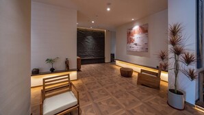 Ein modernes Interieur mit einer Holzbank, einer Topfpflanze und einer Steinwand.