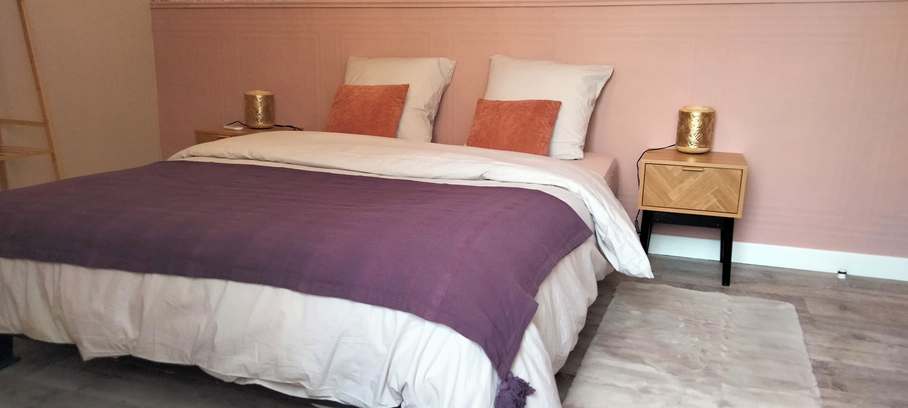 Quarto com uma cama, duas mesas de cabeceira e um tapete.