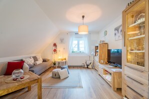Una sala de estar acogedora con sofá, mesa de centro y mueble para televisión.