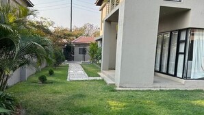 Un edificio moderno con un camino pavimentado que conduce a una entrada con puerta de acceso.