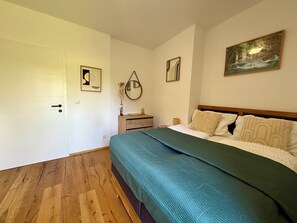 Ein Schlafzimmer mit einem Bett, einem Schminktisch, einem Spiegel und einem Bild an der Wand.