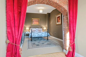 A bedroom with a bed, a nightstand, a lamp, and a framed picture on the wall.