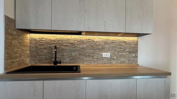 A kitchen with a stone backsplash, a black faucet, and a wooden countertop. - [VE-Mestre Train Station] Relax&Zen Apartment (Venezia)