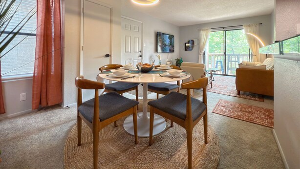 Een eethoek met een ronde tafel, stoelen en een hanglamp.