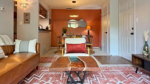 Een woonkamer met een bank, salontafel en een eethoek met een tafel en stoelen.