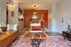 A living room with a sofa, coffee table, and a dining area with a table and chairs. - Modern Nambé Condo: Pool, Gym & Gated, Minutes to Downtown SF (Santa Fe)