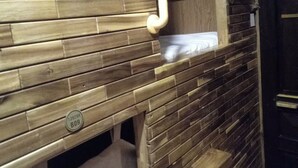 Een houten wand met een ingebouwde bank en een klein plankje.