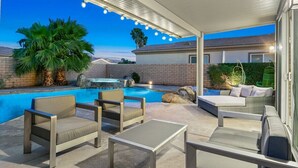 A covered outdoor area with a pool, seating, and a hot tub. - Terra Sol: Pool, Spa & Lakefront Serenity (Indio)