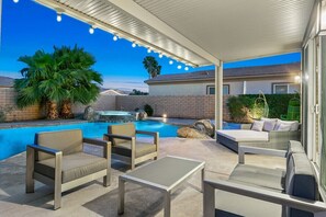 A covered outdoor area with a pool, seating, and a hot tub. - Terra Sol: Pool, Spa & Lakefront Serenity (Indio)