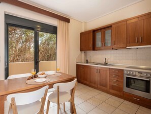 A modern kitchen with wooden cabinets, a stainless steel sink, and a large window with a view of trees. - Corali Villa III - Seaview, Pool & 450m to Beach (Crete)