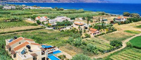 Zona residencial costera con casas, piscina y vista al mar.