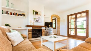 A cozy living room with a fireplace, a television, and a large window. - Awesome home in Arta with private swimming pool, can be inside or outside (Arta)
