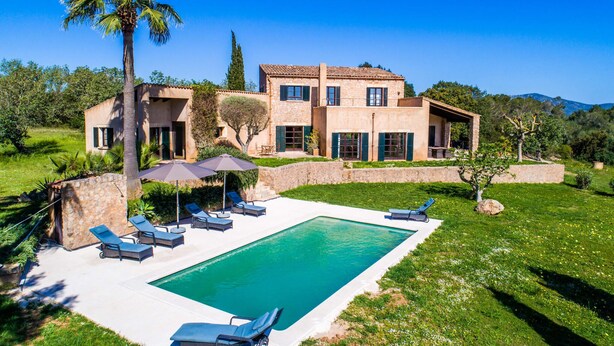 Un'ampia casa con piscina, area relax all'aperto e un giardino curato.
