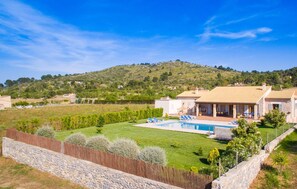 A villa with a swimming pool, surrounded by a well-maintained lawn and stone walls. - Awesome home in Arta with private swimming pool, can be inside or outside (Arta)