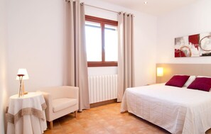 A hotel room with a bed, a chair, a table with a lamp, and a window with curtains. - Awesome home in Arta with private swimming pool, can be inside or outside (Arta)