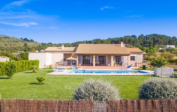 A two-story house with a swimming pool, a patio with lounge chairs, and a view of the surrounding hills. - Awesome home in Arta with private swimming pool, can be inside or outside (Arta)