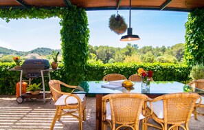 An outdoor dining area with wicker chairs, a glass table, and a hanging light fixture. - Stunning home in Arta with private swimming pool, can be inside or outside (Arta)