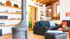 Ein gemütliches Wohnzimmer mit Kamin, Ledersofa und Holzregalen mit verschiedenen Dekorationselementen.
