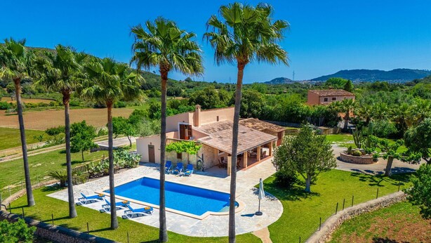 A villa with a swimming pool, surrounded by palm trees and a well-maintained lawn. - Awesome home in Arta with private swimming pool, can be inside or outside (Arta)