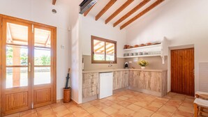 A kitchen with wooden cabinets, a built-in dishwasher, and a window with a view of greenery. - Awesome home in Arta with private swimming pool, can be inside or outside (Arta)