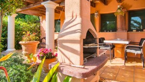 An outdoor patio with a stone oven, seating area, and potted plants. - Awesome home in Cala Ratjada with WiFi (Cala Ratjada)