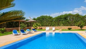 Une piscine avec des chaises longues et un petit pavillon.