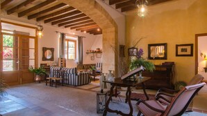 A spacious living room with a high ceiling, wooden beams, a fireplace, and a piano. - Cozy home in Arta with private swimming pool, can be inside or outside (Arta)