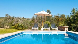 A swimming pool with two lounge chairs and a single umbrella. - Luxurious home in Son Servera (Son Servera)