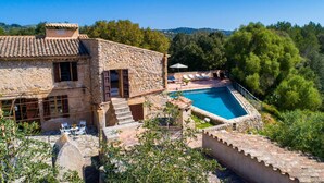 A stone villa with a swimming pool, outdoor seating, and a view of the surrounding forest. - Stunning home in Arta with private swimming pool, can be inside or outside (Arta)