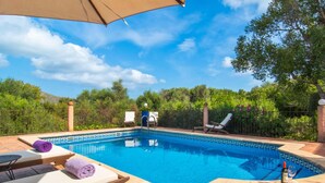 Une piscine avec des chaises longues et une pergola.
