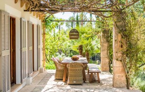 An outdoor patio with wicker furniture, a stone table, and a hanging basket. - Cozy home in Arta with private swimming pool, can be inside or outside (Arta)