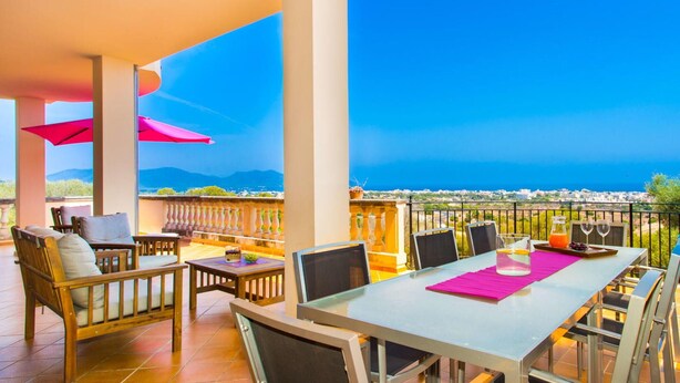 A terrace with a table and chairs, a view of the sea, and a balcony railing. - Lovely home in Cala Millor with private swimming pool, can be inside or outside (Cala Millor)
