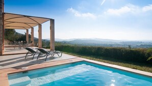 A poolside area with a pergola, lounge chairs, and a view of distant mountains. - Luxurious home in Manacor with private swimming pool, can be inside or outside (Manacor)